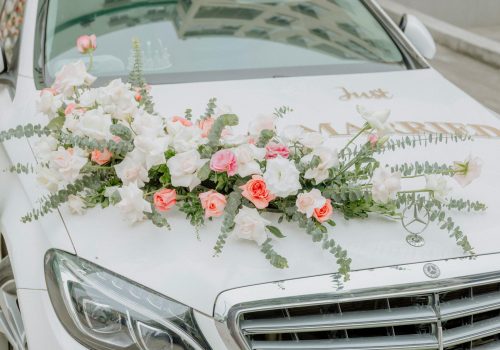 Close-up of a wedding car adorned with beautiful flower arrangements.
